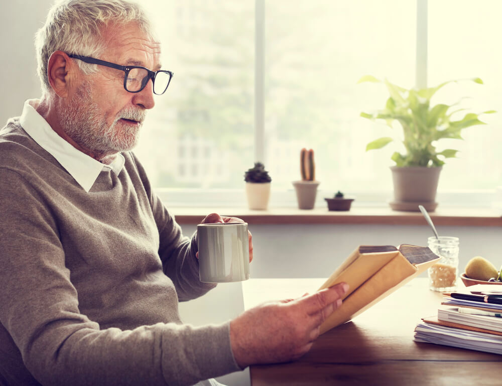 a man enjoys a cup of coffee at a senior assisted living facility