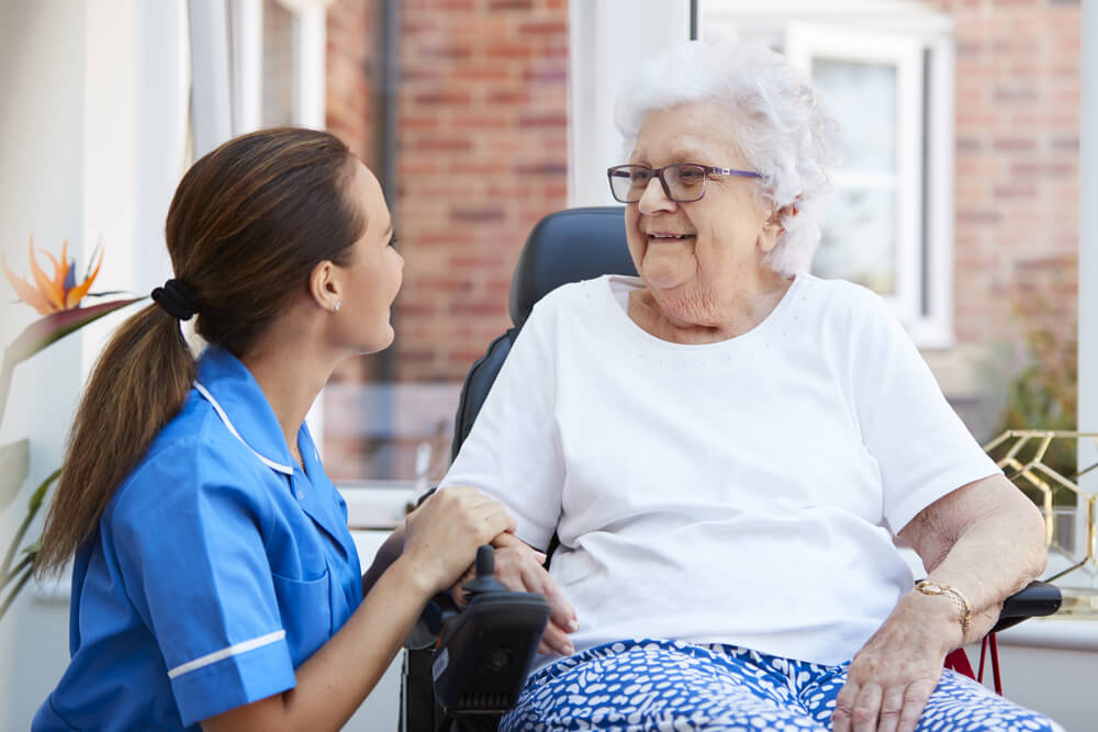 A woman in a wheelchair with a nurse for assisted living near Nisswa, MN at Whitefish at the Lakes.